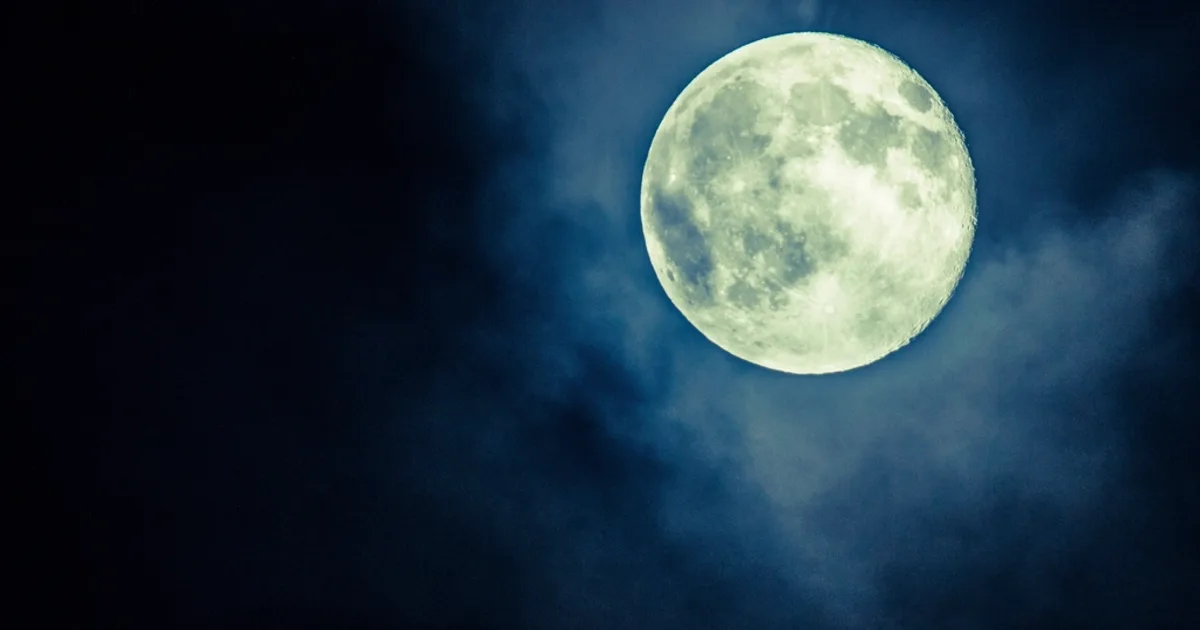 The Moon glowing in a deep blue midsummer night sky